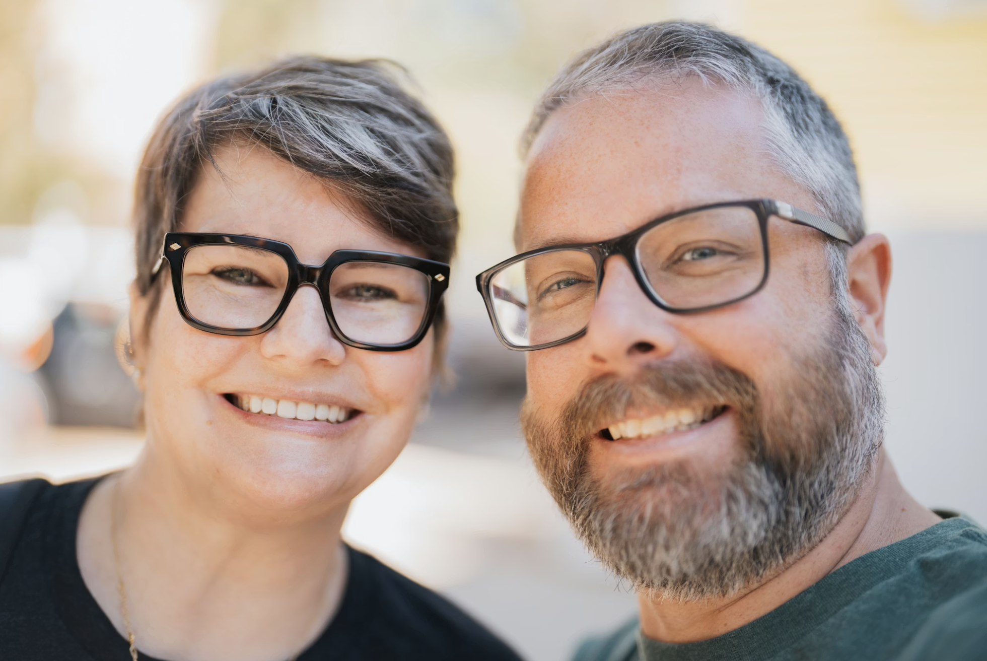 Middle-aged couple in glasses smiling together